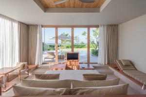 a living room with a couch and a table and chairs at FLC Luxury Resort Quy Nhon in Quy Nhon