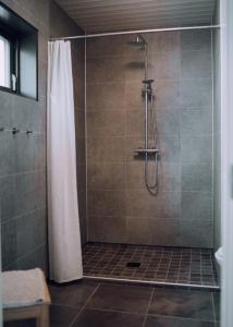 a shower with a shower curtain in a bathroom at Heima Holiday Homes in Selfoss