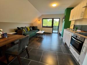 eine Küche und ein Wohnzimmer mit einem Sofa und einem Tisch in der Unterkunft JUNIPRO Apartments & Rooms in Nohfelden