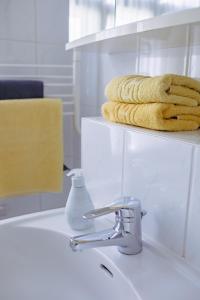 a bathroom sink with a soap dispenser and towels at Villa Meeresblick in Sassnitz
