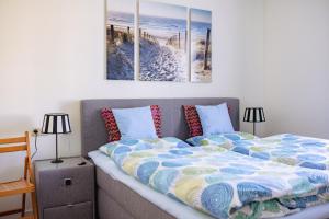 a bedroom with a bed with two paintings on the wall at Villa Meeresblick in Sassnitz