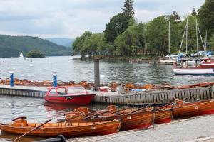 a group of boats docked at a dock on a lake at Ivy Bank Guest House - Room Only in Windermere
