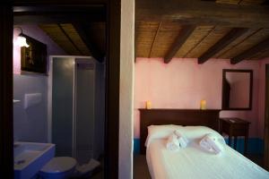 1 dormitorio con cama, bañera y lavamanos en Castello Malicas, en Galtellì
