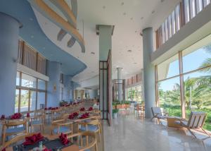 - une salle de banquet avec des tables, des chaises et des fenêtres dans l'établissement FLC Luxury Resort Quy Nhon, à Quy Nhơn