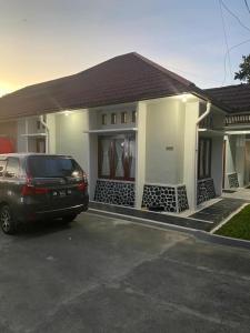 a car parked in a parking lot in front of a house at Villa Syamsu in Bukittinggi +16 photos