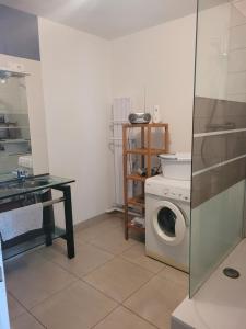 ein Badezimmer mit einer Waschmaschine und einem WC in der Unterkunft La maison de lavande in Laon