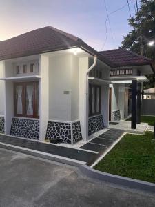 a small white house with a driveway at Villa Syamsu in Bukittinggi
