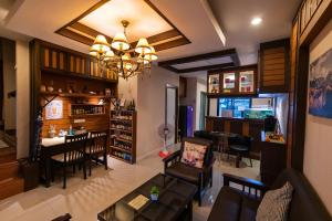 ein Wohnzimmer und ein Esszimmer mit einem Kronleuchter in der Unterkunft AMAZ Bed & Cafe in Ban Pa Faek