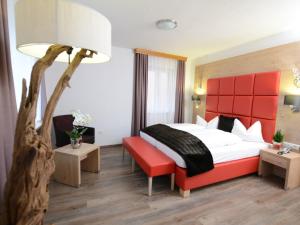 a hotel room with a bed and a red headboard at Land-gut Hotel zum Löwen Garni in Marktheidenfeld