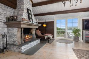 una sala de estar con chimenea de piedra en una casa en Libeli- panoramaview towards Gaustadtoppen- Jacuzzi, en Lona