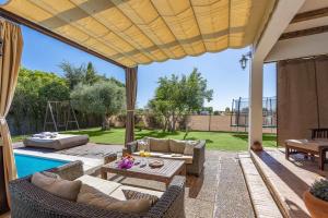 a patio with a table and chairs and a pool at Casa Rural La Teja in Marchena