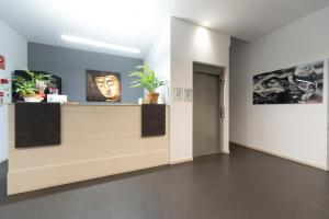 a lobby with a counter with plants on it at Epsilon Alcañiz Hotel in Alcañiz