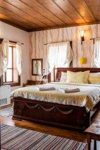 a large bed in a bedroom with a wooden ceiling at Kazasovata Guest House in Tryavna