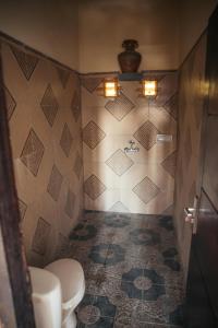 アメッドにあるブキット インダ ホームステイのトイレとタイル張りの壁があるバスルーム