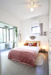 - une chambre avec un grand lit dans une pièce dotée de fenêtres dans l'établissement Design & Balcony in City Center by FeelHome, à Tel Aviv