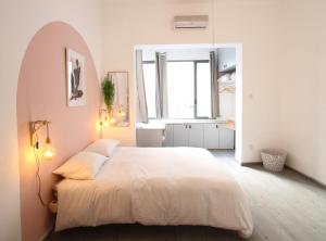 - une chambre avec un grand lit blanc et une fenêtre dans l'établissement Design & Balcony in City Center by FeelHome, à Tel Aviv