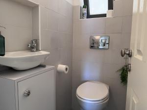 La salle de bains blanche est pourvue de toilettes et d'un lavabo. dans l'établissement Design & Balcony in City Center by FeelHome, à Tel Aviv