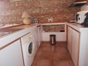 a kitchen with a sink and a washing machine at Fontanelle in Baziège