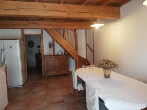a dining room with a white table and a kitchen at Fontanelle in Baziège