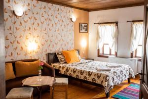 トリャブナにあるKazasovata Guest Houseのベッドルーム1室(ベッド1台、ソファ、テーブル付)