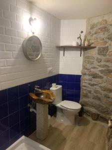 a bathroom with a toilet and a stone wall at ACASADOCRUCEIRO 