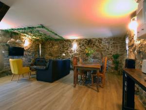 a living room with a table and yellow chairs at ACASADOCRUCEIRO in Vales