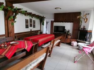 a living room with two tables and a television at Къща за гости Градината in Dobrinishte +6 photos