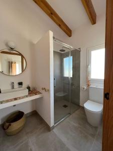 a bathroom with a shower and a toilet and a mirror at Mas Midó in Sant Jaume d'Enveja