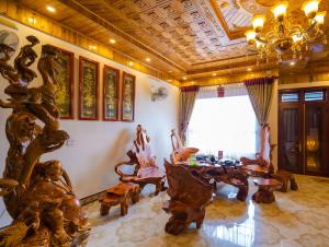 Elle comprend un salon doté d'un mobilier en bois et d'un plafond. dans l'établissement Nhà Nghỉ Xuân Mai, à Lạng Sơn