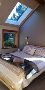 a bedroom with a large bed with a window at Kowhai Cottages - Stunning Mackenzie in Twizel