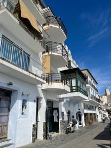 a white building with balconies on a street at Habitatges Turístics Riba Pitxot - Norai in Cadaqués