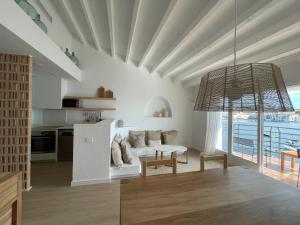 a living room with a white couch and a table at Habitatges Turístics Riba Pitxot - Norai in Cadaqués