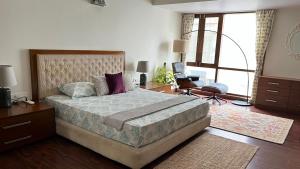 um quarto com uma cama grande e uma janela grande em LUHO Grande em Bangalore