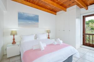 a white bedroom with a large bed and a window at San Lameer Villa 3116 - 3 Bedroom Standard - 6 pax - San Lameer Rental Agency in Southbroom