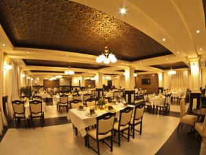 a dining room with white tables and chairs at Hotel Melody in Satu Mare