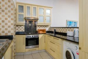 uma cozinha com armários de madeira e um forno com placa de fogão em San Lameer Villa 3116 - 3 Bedroom Standard - 6 pax - San Lameer Rental Agency em Southbroom