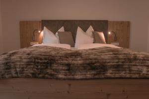 sypialnia z dużym łóżkiem z poduszkami w obiekcie brandgut - vor Freude glühen w mieście Viehhofen