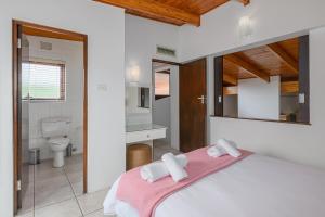 a bedroom with a large bed and a bathroom at San Lameer Villa 3116 - 3 Bedroom Standard - 6 pax - San Lameer Rental Agency in Southbroom