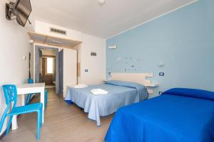 Maresidence Rooms & Breakfast في توري بالي: غرفة نوم بسريرين ومكتب وطاولة