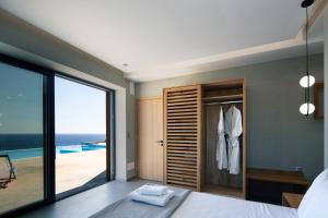 A bed or beds in a room at Seafront elegant villas, with infinity pools & devine views!
