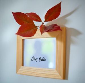 a wooden picture frame with a leaf on a wall at LA MAISON D'ANNIE in Banne
