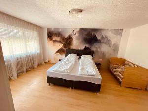 1 dormitorio con 1 cama y una pintura en la pared en Wilhelm, en Hornberg