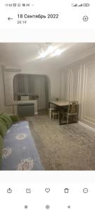 a living room with a bed and a table at Квартира для семьи in Almaty