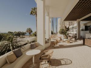 eine Terrasse mit Stühlen und Tischen auf einem Gebäude in der Unterkunft Comfy Studios in Benalmádena