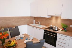 a kitchen with a table with a plate of fruit on it at Baabe Villen Ensemble FeWo 30 Stra in Baabe