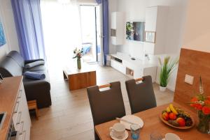 a kitchen and living room with a table and chairs at Baabe Villen Ensemble FeWo 30 Stra in Baabe