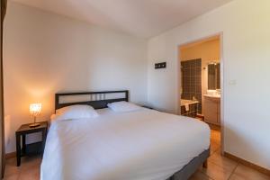 - une chambre avec un grand lit blanc et une salle de bains dans l'établissement Cerise Carcassonne Sud, à Carcassonne