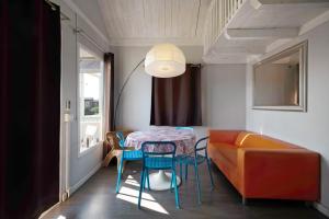una camera con tavolo, sedie e divano di Camping Grande Italia Chalet Mare a Chioggia