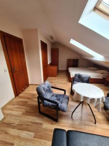 a room with two chairs and a table and a bed at Gościniec Halka in Zwardoń