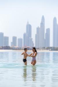 a woman in a bikini on a body of water at Raffles The Palm in Dubai